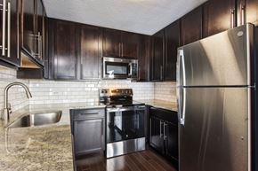 Chicago apartment for rent - a kitchen with stainless steel appliances and dark wood cabinets