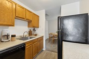 Dumfries apartment for rent - Kitchen with a sink and refrigerator and a dining room with a table at Briarwood Apartments, Dumfries, Virginia