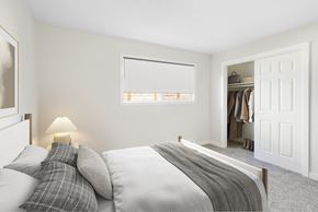 Milwaukie apartment for rent - A bedroom with a bed, pillows, a lamp, and a closet.