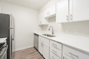 Milwaukie apartment for rent - A kitchen with white cabinets and a black refrigerator.