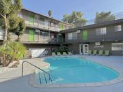 Riverside apartment for rent - A pool in front of a lounge area with a building in the background.