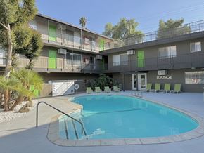 Riverside apartment for rent - A pool in front of a lounge area with a building in the background.