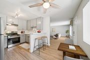Riverside apartment for rent - A kitchen with a refrigerator, stove, and bar stools.