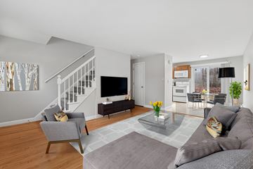 Vernon apartment for rent - A living room with a grey couch, a grey armchair, a glass coffee table and a television.