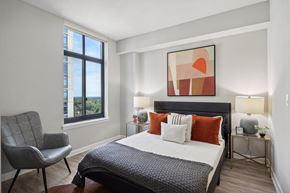 Wheaton apartment for rent - a bedroom with a bed and a large window
