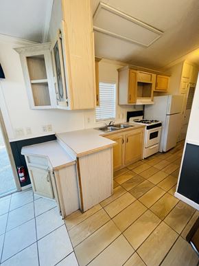 Salinas apartment for rent - A kitchen with wooden cabinets and a white counter.