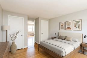 Manchester apartment for rent - A bedroom with a bed, nightstand, and a vase on a wooden table.