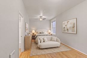 Portland apartment for rent - A bedroom with a bed, a couch, and a painting on the wall.
