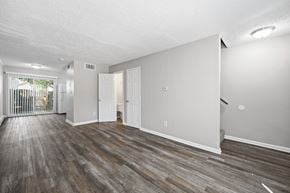Winchester apartment for rent - A spacious room with wooden flooring and white walls.