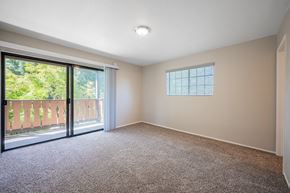 Solvang apartment for rent - an empty living room with a sliding glass door to a balcony at Oak Park Apartments, Solvang, CA