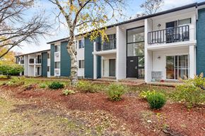 Madison apartment for rent - A row of modern townhouses with white and green exteriors.