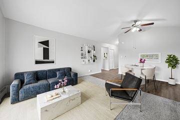 North Aurora apartment for rent - A living room with a blue couch, a white coffee table, and a ceiling fan.
