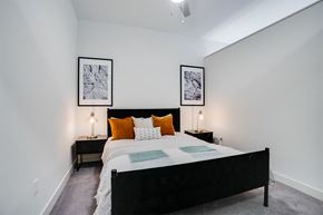 Minneapolis apartment for rent - A bedroom with a large bed and two framed pictures on the wall at Sora Apartments, Minnesota, 55415