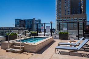 Minneapolis apartment for rent - A pool on a rooftop with lounge chairs and a building in the background at Sora Apartments, Minnesota