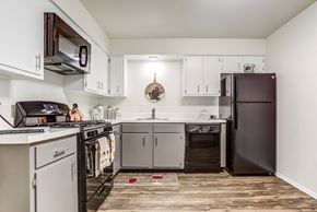 St. Charles apartment for rent - a kitchen with white cabinets and black appliances at The Township at St. Charles, St. Charles, IL