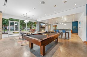Minneapolis apartment for rent - A pool table is in the middle of a room with a bar and a television.