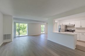 Wayzata apartment for rent - A spacious kitchen with white cabinets and a stainless steel refrigerator.