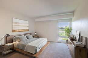 Wayzata apartment for rent - A bedroom with a large bed and a painting on the wall.