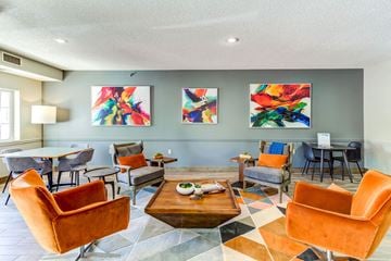 Chaska apartment for rent - a living room with orange chairs and a table