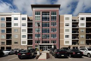Pittsburgh apartment for rent - A parking lot with cars in front of apartment buildings.at Cosmopolitan Apartments, Pittsburgh Pennsylvania