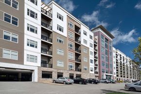 Pittsburgh apartment for rent - A multi-story apartment building with a parking lot at Cosmopolitan Apartments, Pittsburgh, PA