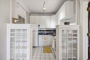 Oak Park apartment for rent - a white kitchen with white cabinets and a yellow rug at The Bryant at Oak Park I & II, Oak Park
