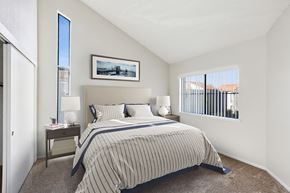 Vacaville apartment for rent - A bedroom with a bed, nightstand, and a painting on the wall.