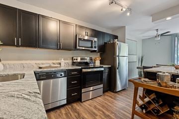 Wheaton apartment for rent - A modern kitchen with black cabinets and stainless steel appliances.