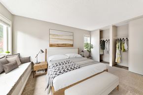Tualatin apartment for rent - A bedroom with a large bed, a bench, and a wardrobe.