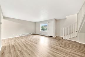 Tualatin apartment for rent - A spacious livingroom with wooden flooring and a staircase at River Lofts Apartments, Oregon