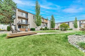 Tualatin apartment for rent - A sunny day at a well-kept apartment complex with a green lawn and trees. at River Lofts Apartments, Tualatin, Oregon