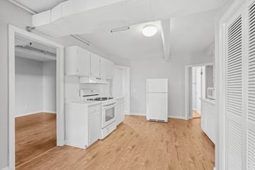 Burlington apartment for rent - A kitchen with white cabinets and a wooden floor.