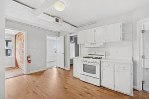 Burlington apartment for rent - A kitchen with white appliances and wooden floors.
