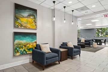 Wheaton apartment for rent - A living room with two blue couches and two paintings on the wall.