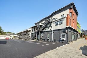 Burlington apartment for rent - A parking lot with a building that has a staircase on its side.