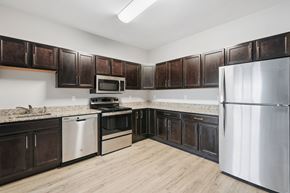 Stratford apartment for rent - A kitchen with dark brown cabinets and stainless steel appliances.