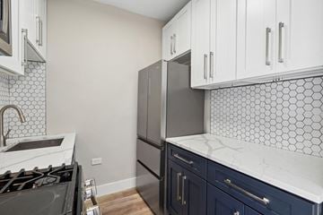 Oak Park apartment for rent - A kitchen with a black stove top oven and a black refrigerator.