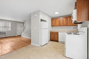 Vernon apartment for rent - A kitchen with white appliances and wooden cabinets.