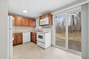 Vernon apartment for rent - A kitchen with white appliances and wooden cabinets.