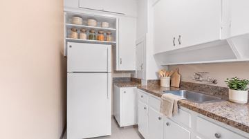 Portland apartment for rent - A white refrigerator is in a kitchen with a sink and counter.