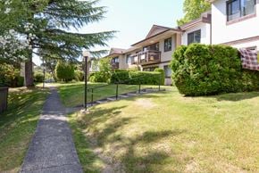 Vancouver apartment for rent - A pathway leads through a grassy area in front of a building.
