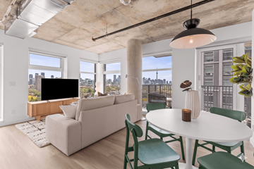 Toronto apartment for rent - A living room with a white couch and green chairs.