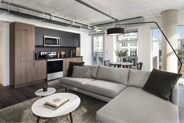 Toronto apartment for rent - A modern living room with a grey sofa and a coffee table.