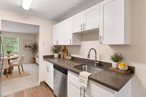 Puyallup apartment for rent - A kitchen with white cabinets and a black countertop.