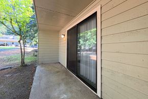 Federal Way apartment for rent - A sliding glass door with a black frame is on the side of a house.