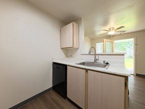 Puyallup apartment for rent - A kitchen with a black dishwasher and a white countertop.