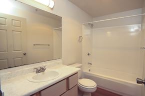 Puyallup apartment for rent - A white bathroom with a toilet, sink, and bathtub.