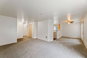 Puyallup apartment for rent - A spacious room with a ceiling fan and carpeted floor.