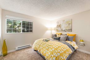 Federal Way apartment for rent - A bedroom with a yellow bedspread and a window with blinds.