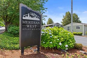 Puyallup apartment for rent - A sign for Meridian West Apartments is shown in front of a building.